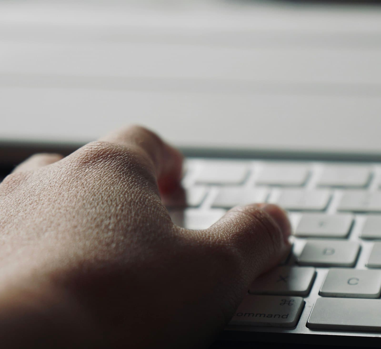 Gros plan sur une main tapant sur un clavier d'ordinateur portable