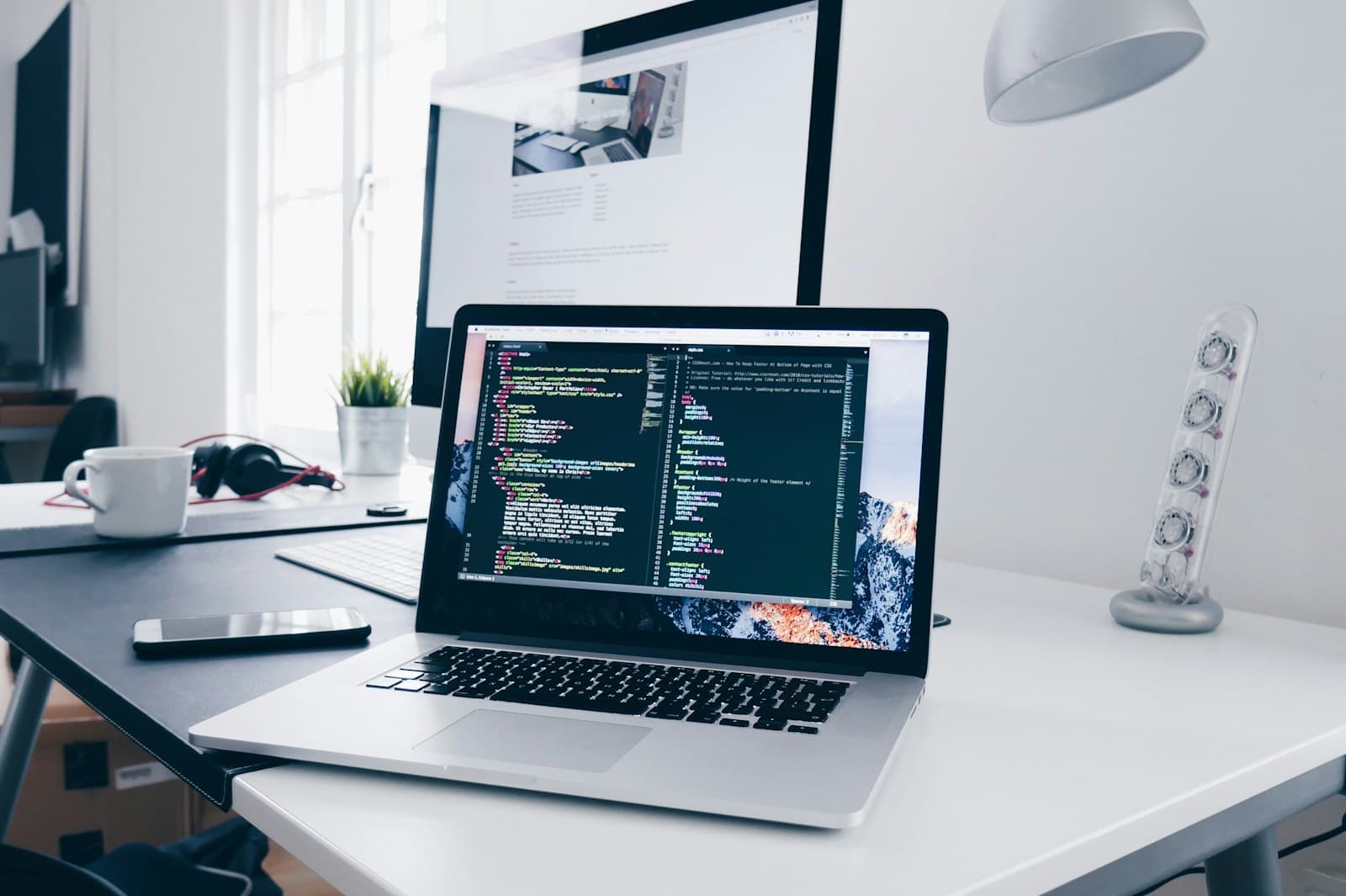 Écran d'ordinateur portable affichant du code, sur un bureau clair et épuré